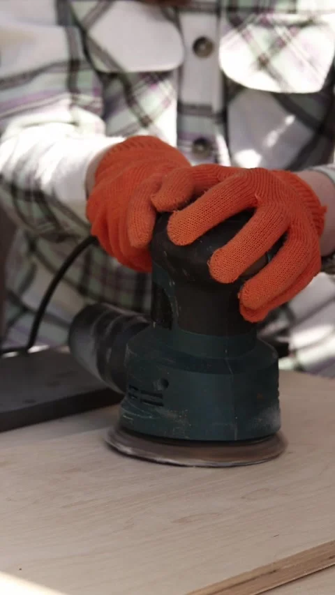 Worker sands a wooden surface with an orbital sander Video stock 335276592