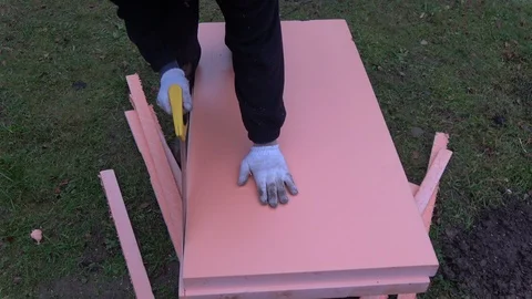 Worker with saw cut insulation polystyrene for foundation Stock Footage 87315248