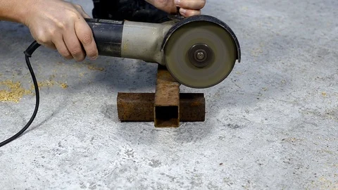Worker sawing a disk of metal square profile Stock Footage 121961070