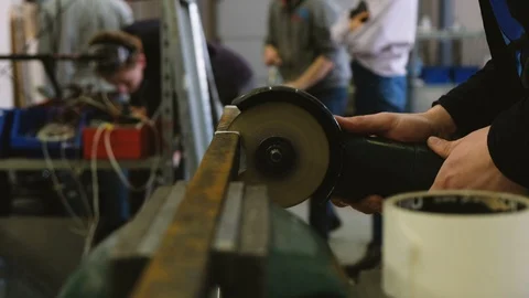 Worker sawing metal bar of angular grinding machine. Video stock 87942551