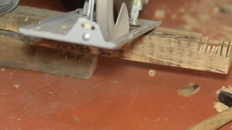 Worker saws the board with circular saw, repairs house with an electric saw Stock Footage 76331679