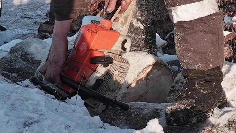 A worker saws a log filled with snow into pieces. Close-up. Stock Footage 170850025