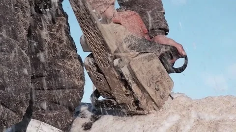 A worker saws a log filled with snow into pieces. Close-up. Stock Footage 170850265