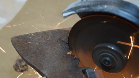A worker saws a part from a metal piece with an electric circular saw. Stock Footage 156342001