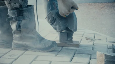 Worker saws paving slabs, repairs on a city street Stock Footage 116770309
