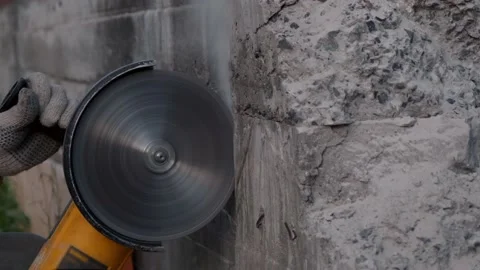 Worker saws stone with circular saw for repairing. Power-saw with disk. Slow Stock Footage 133293030