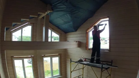 Worker on scaffolding sets window in wooden house made of logs. Time lapse Stock Footage 67211263