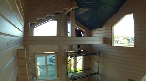 Worker on scaffolding sets window in wooden house made of logs. Time lapse Stock Footage 67289951