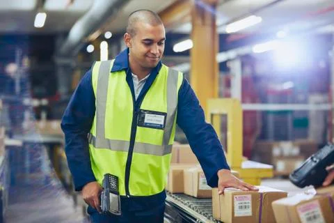Worker with scanner scanning and processing boxes on conveyor belt in Photos