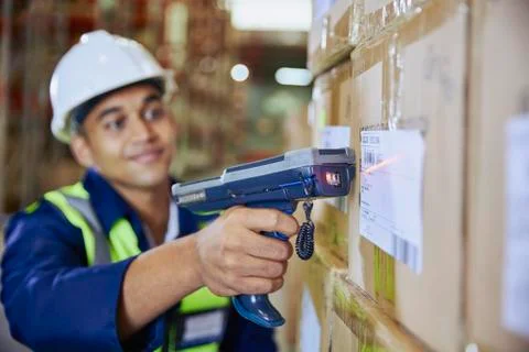 Worker with scanner scanning barcode on box in distribution warehouse Stock Photos