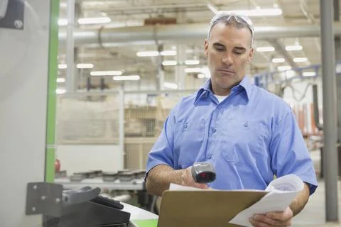 Worker scanning document in factory 库存照片
