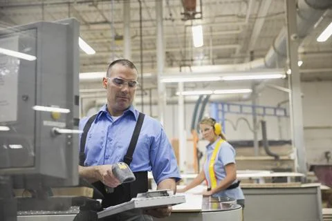 Worker scanning document in manufacturing plant Stock Photos
