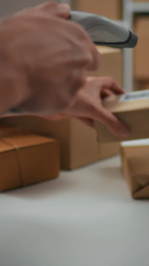 Worker scans barcode on package for inventory tracking at a distribution cen Stock Footage 331740071
