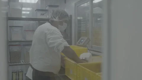 Worker scooping ingredients from storage bin Stockbeeldmateriaal 327353293