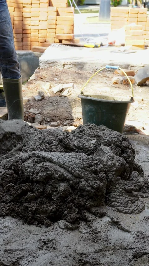 Worker Scooping Wet Cement Mortar into Bucket on Building Site Stock Footage 340543345