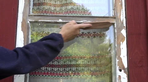 Worker  scraping old paint from house window Stock Footage 41333260