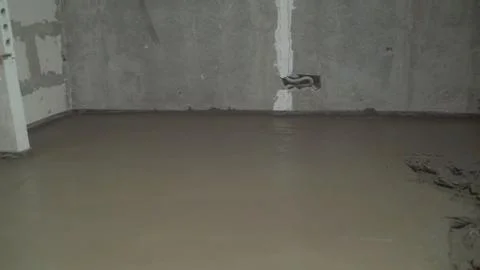 Worker screeding sand bedding to level for laying granite paver blocks. Layin Stock Photos