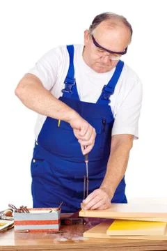 Worker screwing nail in panel board Stock Photos