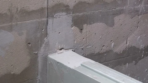 Worker screws a corner to the wall with a screwdriver Stock Footage 115419675