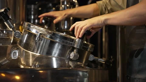 A worker screws the lid of the brewing tank equipment. Stock Footage 220067082