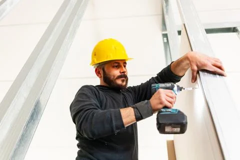 Worker screws plasterboard panels Stock Photos
