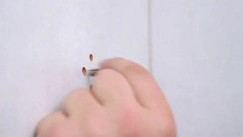 Worker screws screw with electric screwdriver through protective fasteners in Stock Footage 135381441