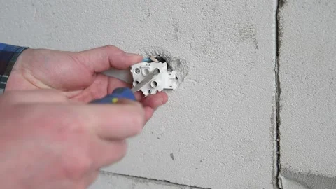 The worker screws the socket to the concrete wall. Stock Footage 151195017