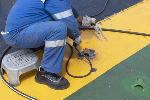Worker at sea during welding Stock Photos