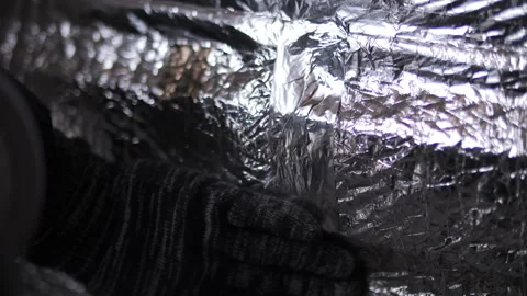 Worker sealing foil insulation with adhesive tape Stock Footage 315956842