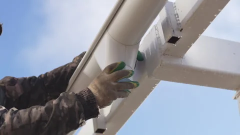 Worker secures nozzle to rainwater pipe with wrench turns Stock Footage 310603174