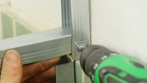 Worker secures panels with screw using electric screwdriver Stock Footage 304406493