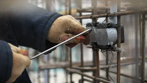 Worker Securing Electrical Box to Rebar Framework Stock Footage 297497790