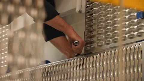 Worker securing metal panels near wall with screwdriver to conceal radiators. Video stock 313815317