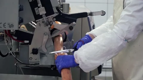 Worker separating sausages using machine at food factory. Stock Footage 146649198