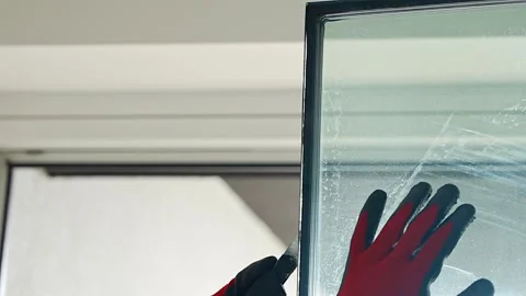 Worker separating triple glazed window glass unit into individual panels for Stockbeeldmateriaal 344519548