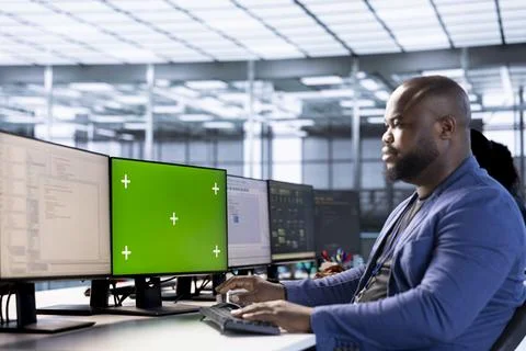 Worker in server hub using green screen computer to find misconfigurations Stock Photos