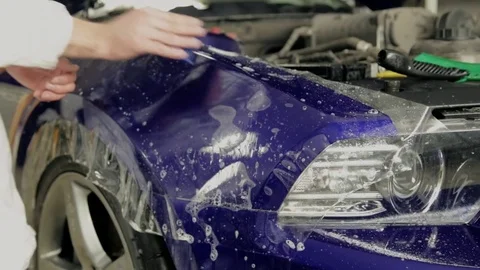 Worker at the service station paste vinyl in an expensive car. Stock Footage 73360969