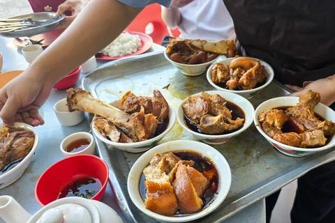 Worker serving authentic and original Klang bak kut teh in multiple small bowls Stock Photos