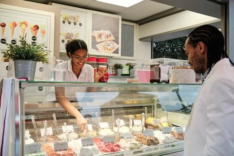 Worker serving a customer in an ice-cream shop Stock Photos