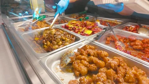 Worker serving orange chicken at Chinese buffet with copy space Видео 331290886