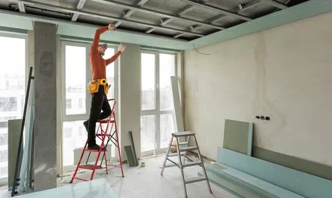 Worker set the ceiling profile in the new flat 写真素材