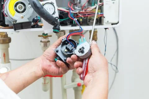 Worker set up central gas heating boiler at home Stock Photos