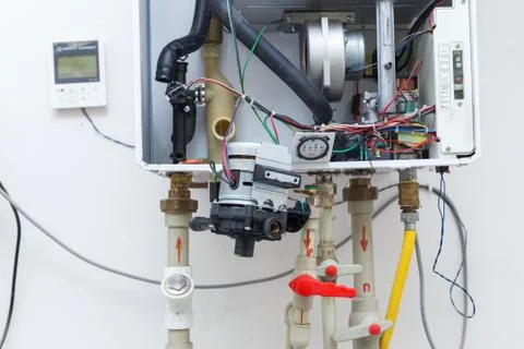 Worker set up central gas heating boiler at home Stock Photos