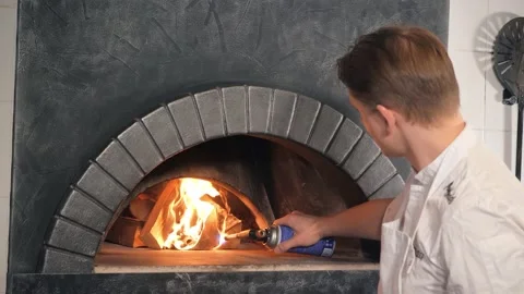 Worker sets fire to wood using gas-burner increasing flame Video stock 132735068