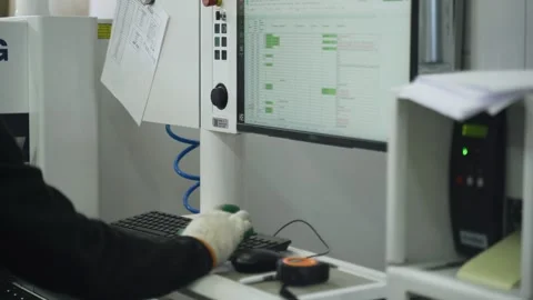 A worker sets parameters on the computer of a modern machine for cutting plates Stock Footage 255852670
