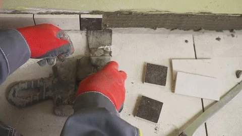 Worker sets small tiles on the wall in the kitchen. His hands are placing the Видео 88692854