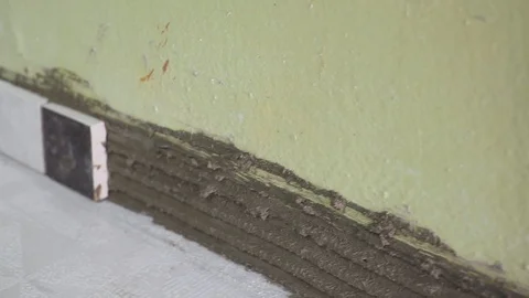 Worker sets small tiles on the wall in the kitchen. His hands are placing the Stock Footage 102073480