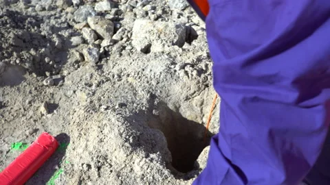 A worker setting up explosives on the ground on a mining quarry Stock Footage 232581069