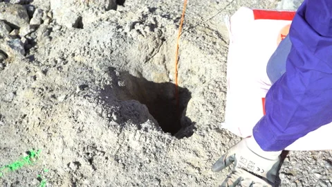 A worker setting up explosives on the ground on a mining quarry Stock Footage 232581664