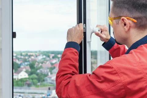 Worker setting up a window. Close-up of handyman setting new windows Stock Photos